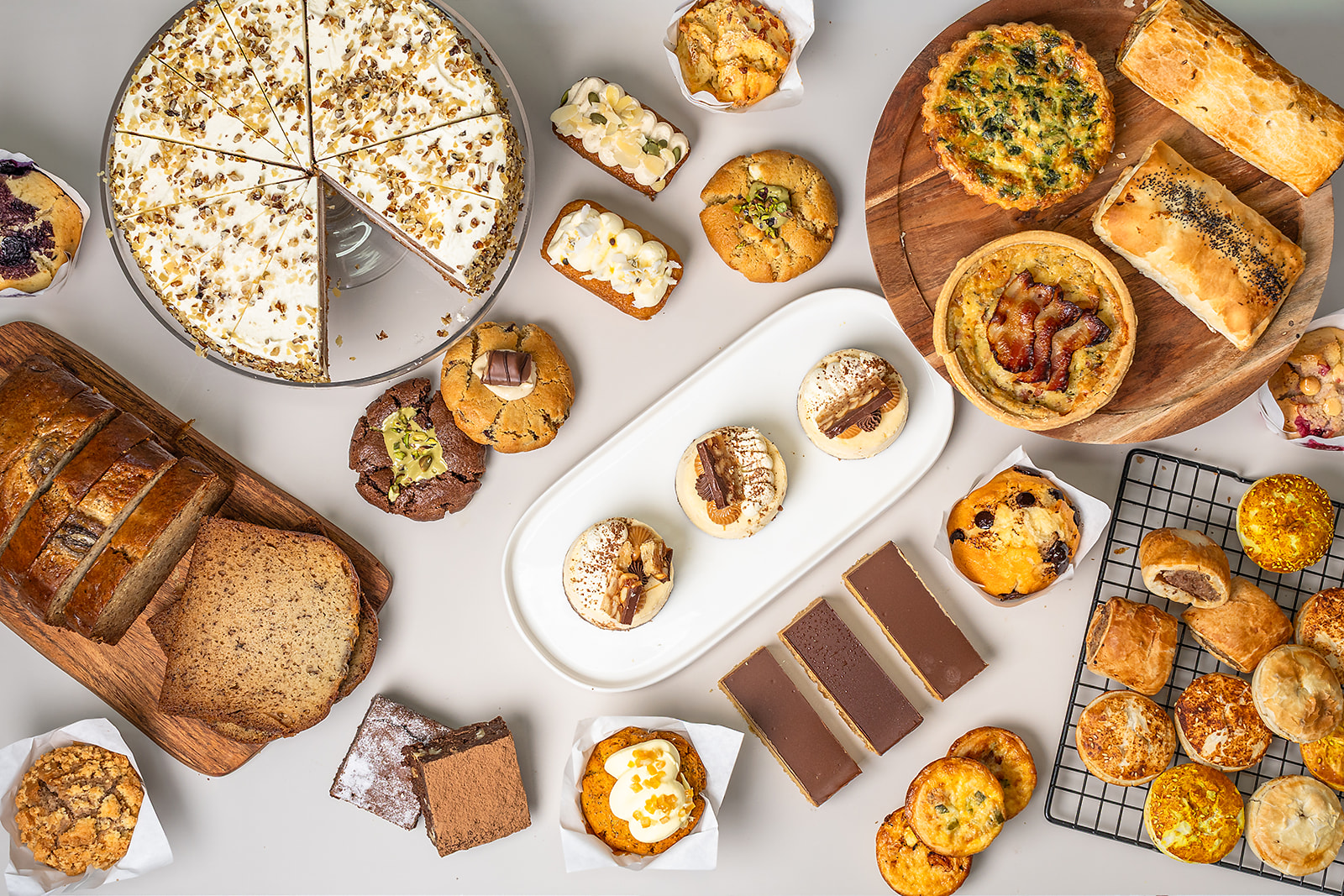 A spread of premium cakes, slices, muffins, and savoury pastries